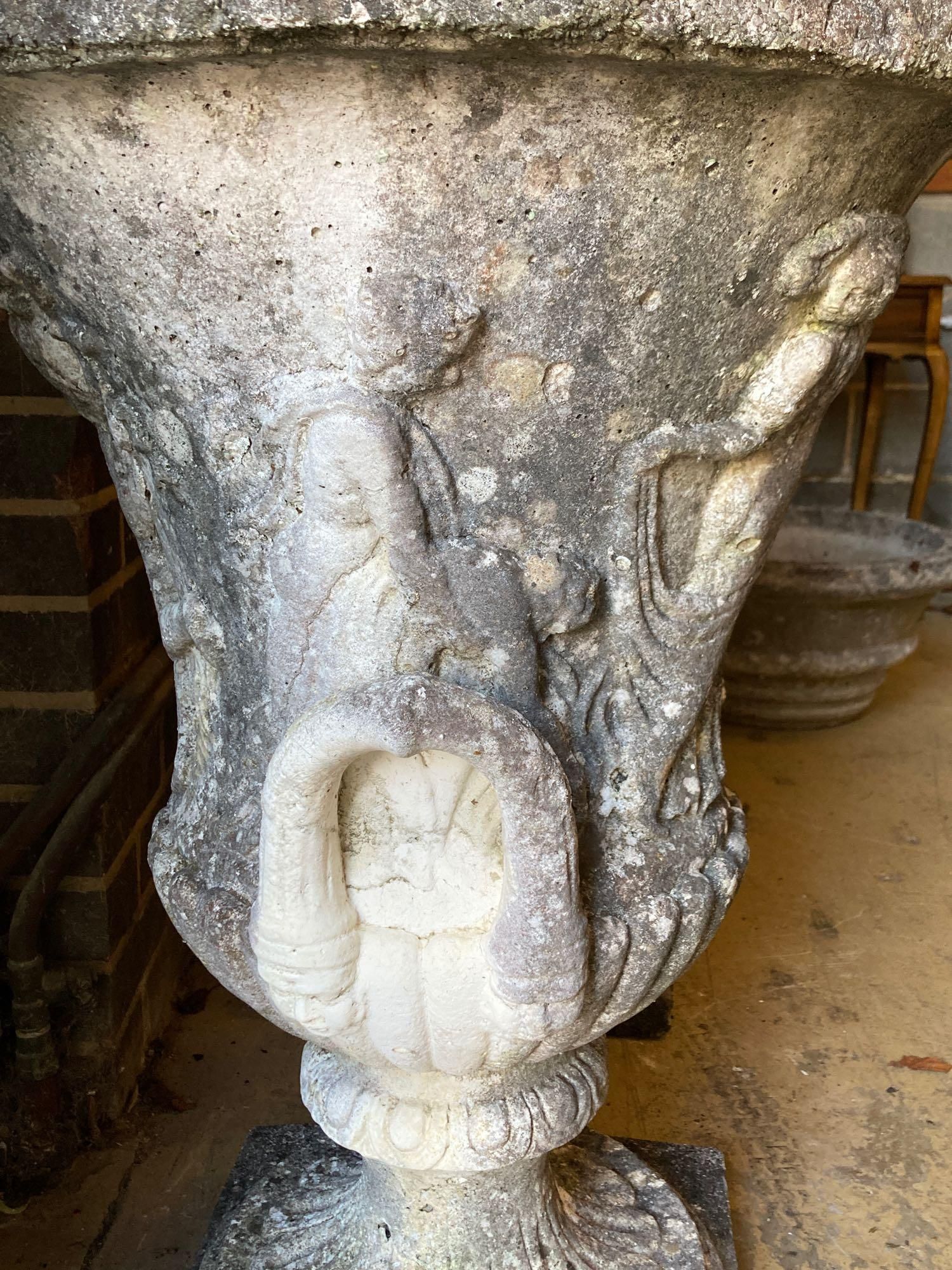 A pair of weathered composition stone urns and pedestals, diameter 56cm height 81cm